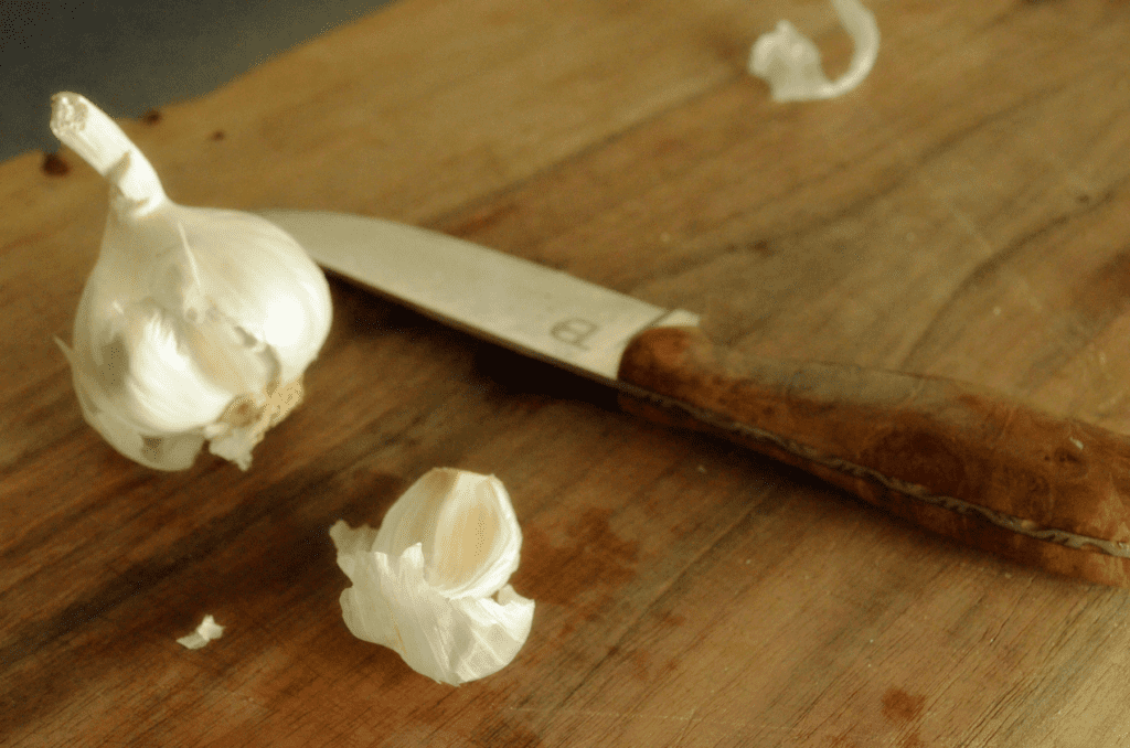 garlic and knife on cutting board