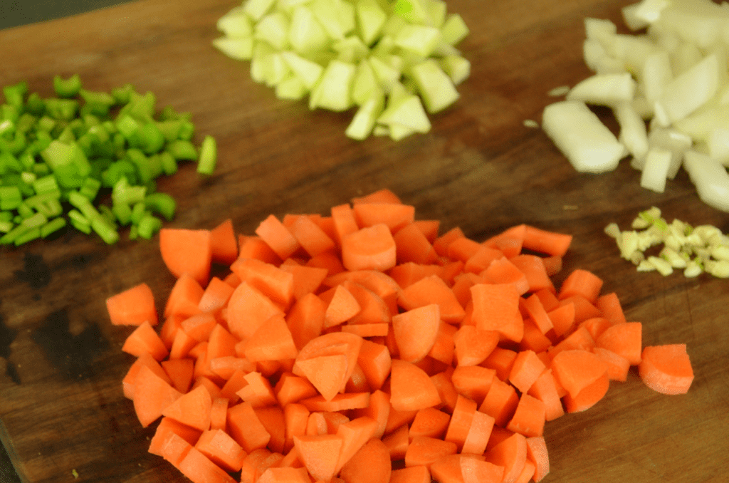 chopped carrots, celery, garlic and onion on cutting board
