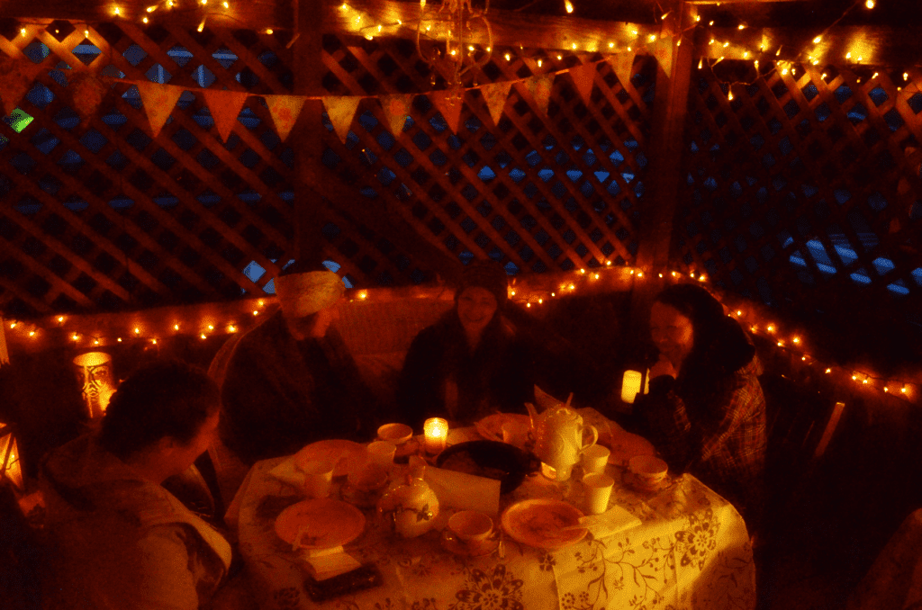 ladies talk around a dimly lit table with twinkle lights and candles