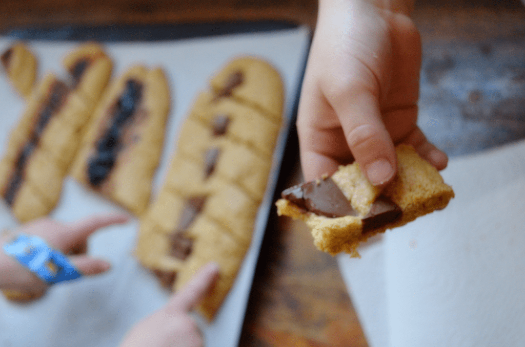 little hand holds up half eaten cookie 