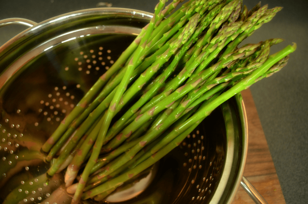 freshly washed asparagus in colander
