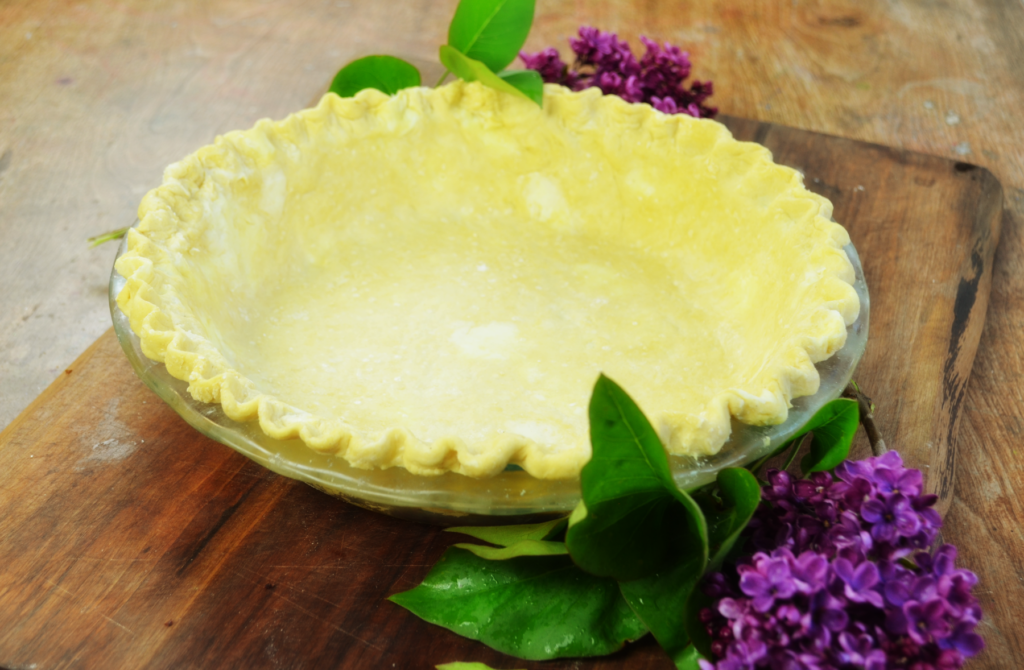 a flaky pie crust sits ready to be filled and baked.