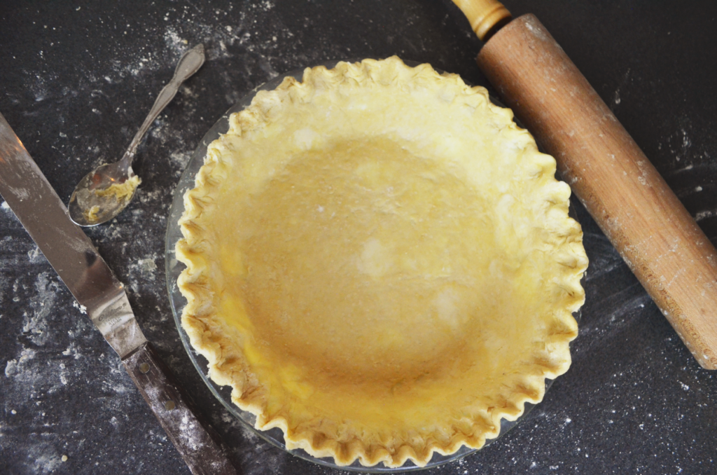 Perfect flaky einkorn pie crust surrounded by rolling pin and spatula