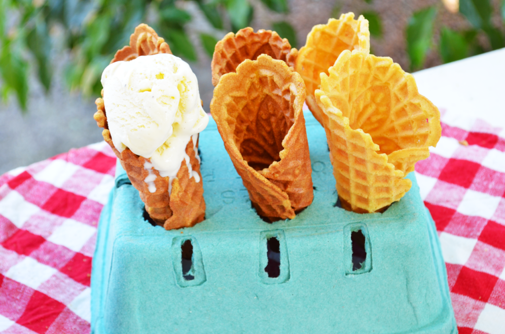 An einkorn waffle cone recipe made using a pizzelle press creates these fabulous ice cream cones. Vanilla ice cream drips down a cone ready to be eaten.