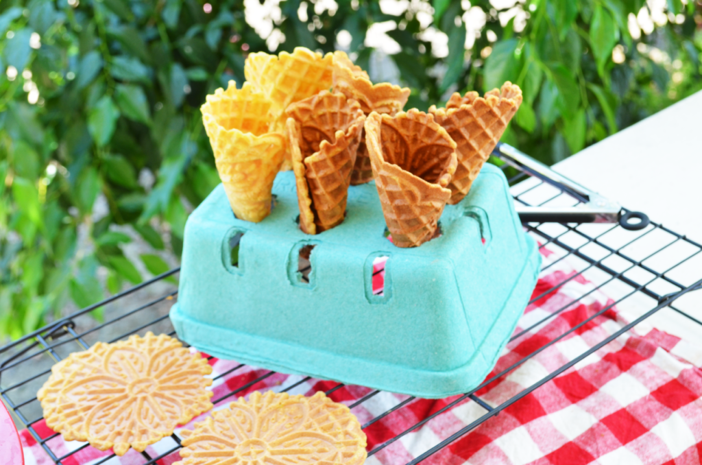 A mint green box turned waffle cone holder supports six finished einkorn waffle cones.