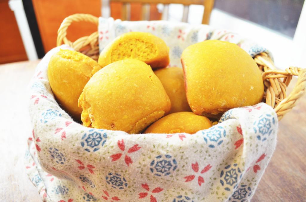 Einkorn flour dinner rolls in a bread basket await a meal. 