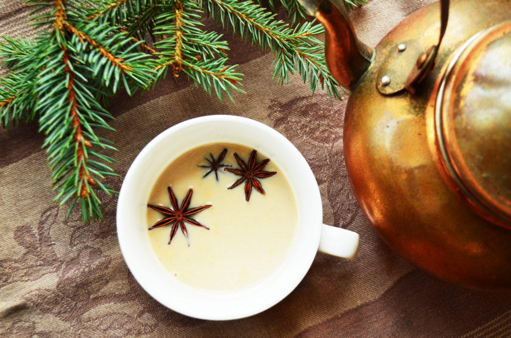 creamy christmas morning chai tea in a white cup with anise stars sitting on top.