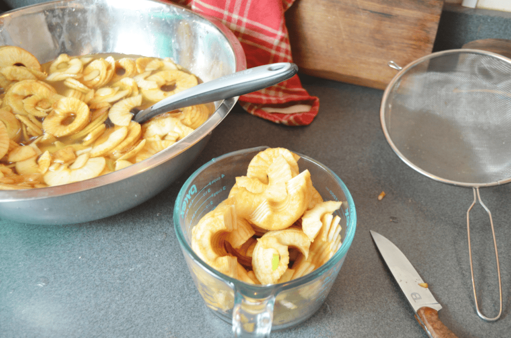 Juicy sliced apples fill a pyrex measuring cup