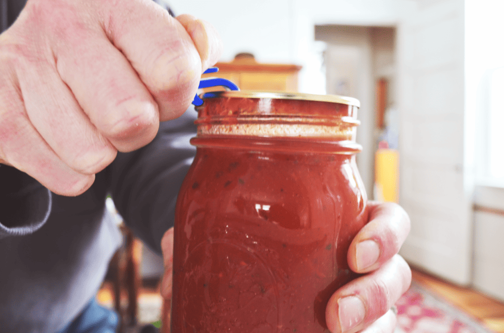 A bottle opener opens a canning jar