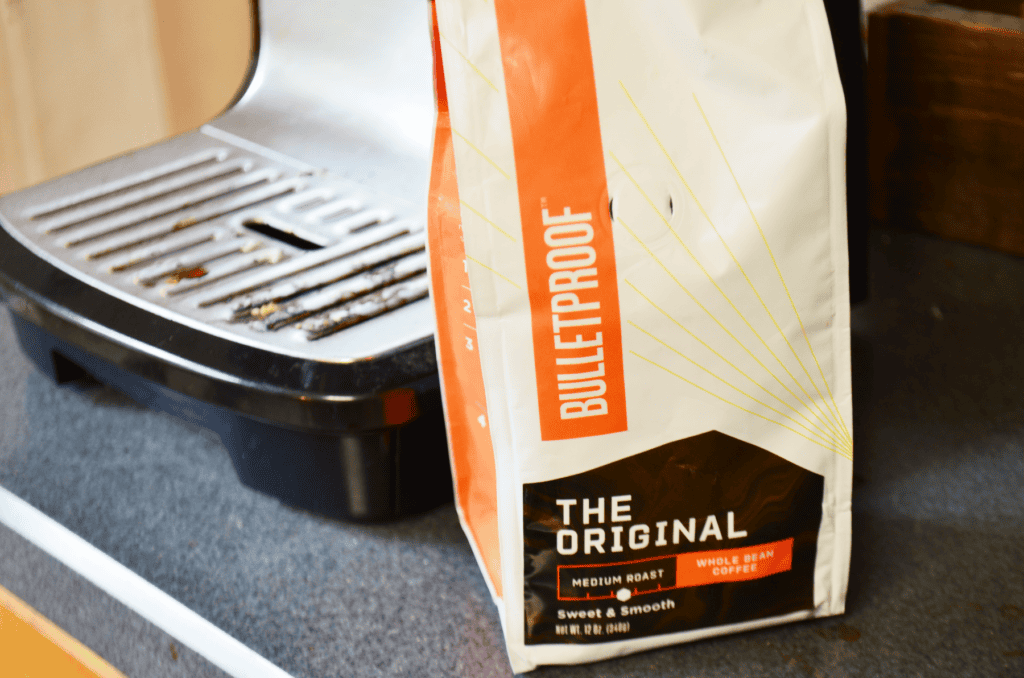 A Bulletproof coffee bag sits in front of an espresso machine
