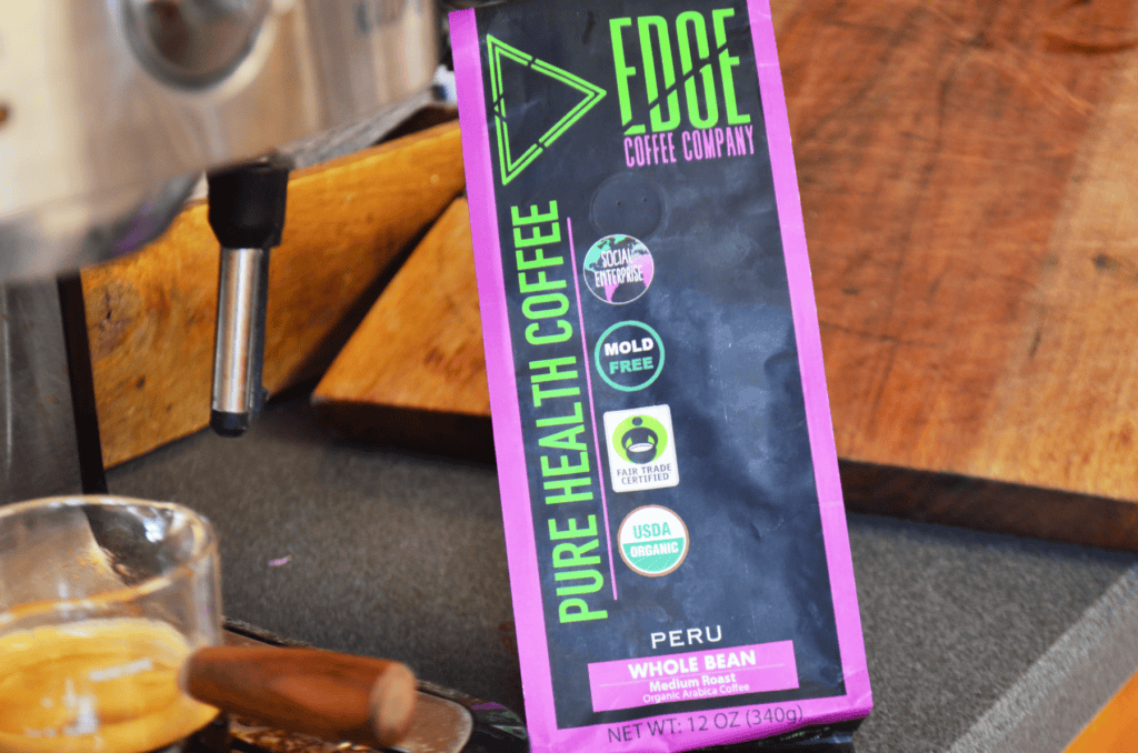 The Edge Coffee bag sits next to an espresso machine with a shot of made espresso.