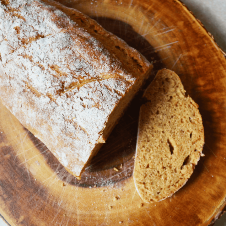 whole wheat sourdough loaf cut fresh on a wooden cutting board