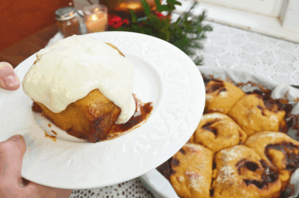 White plate of einkorn cinnamon rolls with frosting