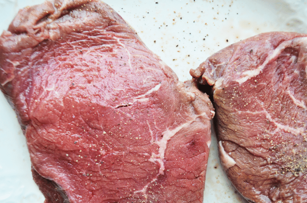 raw steak sitting at room temperature to bake in the skillet to oven method
