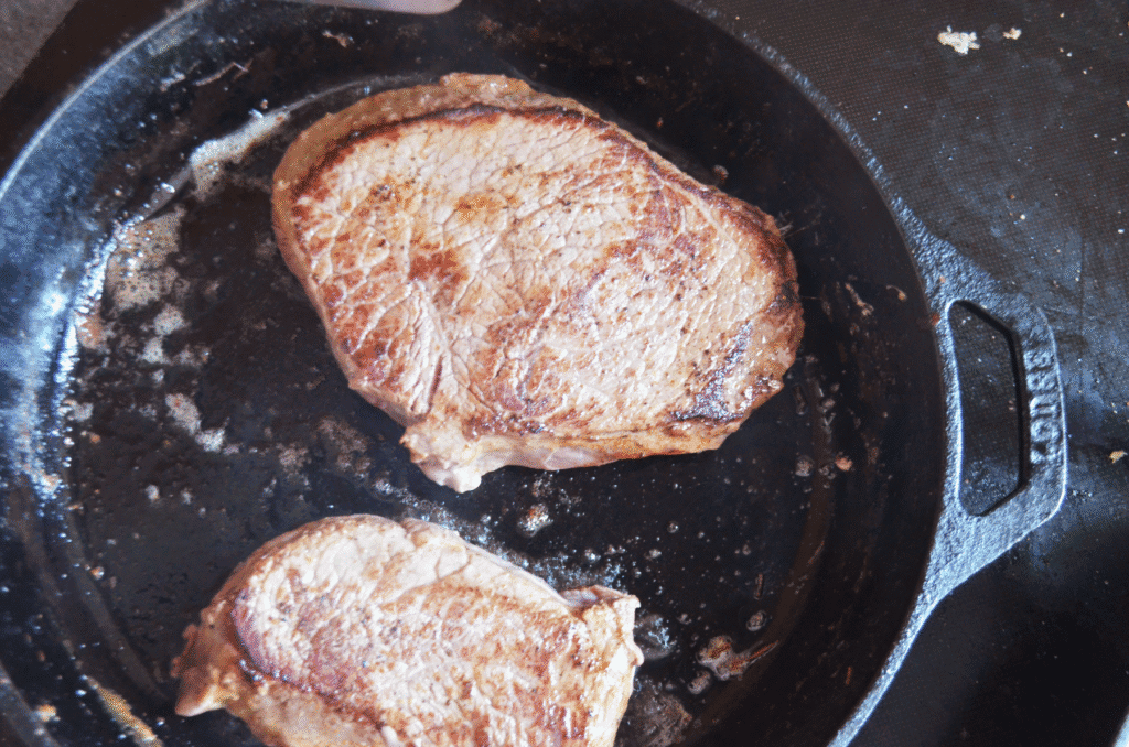 homemade steak searing in a cast iron skillet